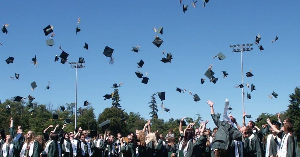 Teens at graduation throwing caps